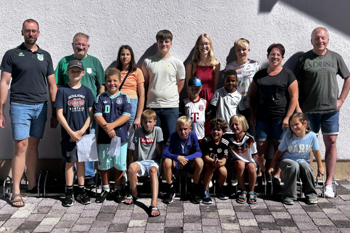 Gruppenfoto der Teilnehmerinnen und Teilnehmer des Ferienprogramms der Schützensektion Oberding mit Betreuern vor dem Vereinsgebäude in Oberding.